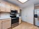 Kitchen with stainless steel appliances, light wood cabinets, wood-look flooring, and white walls at 2906 Crescent Knoll Dr, Matthews, NC 28105