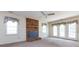 Living room with a brick fireplace, fan and multiple windows and glass paneled doors at 2906 Crescent Knoll Dr, Matthews, NC 28105