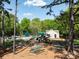 Community playground featuring multiple slides, climbing structures, picnic tables, and a pool in the background at 2906 Crescent Knoll Dr, Matthews, NC 28105