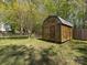 Wooden shed with a classic barn door style, nestled in a grassy backyard with a partially fenced perimeter at 2906 Crescent Knoll Dr, Matthews, NC 28105