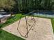 Playground featuring a swing set on a wood chip surface, a bench, and a tennis court in the background at 2906 Crescent Knoll Dr, Matthews, NC 28105
