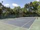 A well-maintained tennis court with a fresh blue surface, enclosed by a tall, secure green fence at 2906 Crescent Knoll Dr, Matthews, NC 28105