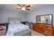This bedroom features a gray upholstered headboard, wooden dresser, and a wooden framed mirror at 2981 Deep Cove Nw Dr, Concord, NC 28027