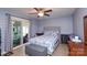 This is a cozy bedroom with a gray upholstered headboard and a sliding glass door to the sunroom at 2981 Deep Cove Nw Dr, Concord, NC 28027