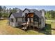 Spacious backyard featuring a covered deck with black railing and stairs to ground at 3500 Manna Ln, Mount Holly, NC 28120