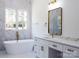 Stylish bathroom featuring a freestanding tub, gold fixtures, marble countertops and light-filled windows at 3500 Manna Ln, Mount Holly, NC 28120