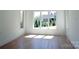 Sun-drenched bedroom with large windows offers a tranquil retreat with light hardwood floors at 3500 Manna Ln, Mount Holly, NC 28120