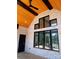 Stylish covered patio with brick columns, wood ceiling, and black framed windows and doors at 3500 Manna Ln, Mount Holly, NC 28120