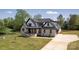 Beautifully landscaped two-story home featuring a large driveway and a manicured lawn at 3500 Manna Ln, Mount Holly, NC 28120