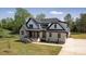 Beautiful two-story home with light brick, black trim, a covered porch, and a manicured lawn at 3500 Manna Ln, Mount Holly, NC 28120