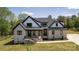 Charming two-story home with light brick, black trim, a covered porch, and a manicured lawn at 3500 Manna Ln, Mount Holly, NC 28120