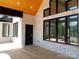 Covered porch with black framed windows, whitewashed brick and a tongue and groove ceiling at 3500 Manna Ln, Mount Holly, NC 28120