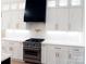 Bright kitchen features modern appliances, white cabinets, gold fixtures and a statement black range hood at 3500 Manna Ln, Mount Holly, NC 28120