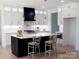 A spacious kitchen with a black island, a white countertop, and modern, stainless steel appliances at 3500 Manna Ln, Mount Holly, NC 28120