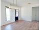 Open living space boasts light hardwood floors, a modern chandelier, and a door to a covered balcony at 3500 Manna Ln, Mount Holly, NC 28120