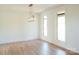 Bright, open living space with light hardwood floors and a modern chandelier, filled with natural light from the windows at 3500 Manna Ln, Mount Holly, NC 28120