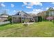 Expansive backyard of brick home, featuring screened porch, patio, and well-manicured lawn at 4715 Amberside Dr, Rock Hill, SC 29732