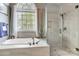 Luxury bathroom features a soaking tub, frameless glass shower, and large window at 4715 Amberside Dr, Rock Hill, SC 29732