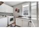 Functional laundry room with modern washer, dryer, sink, and cabinetry at 4715 Amberside Dr, Rock Hill, SC 29732