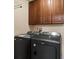 Laundry room with front load black washer and dryer and overhead dark wood cabinetry at 475 Delta Dr, Fort Mill, SC 29715