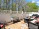 Stone patio enclosed with a white fence, featuring a fire pit table and outdoor seating at 475 Delta Dr, Fort Mill, SC 29715