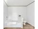 Bright bathroom featuring a soaking tub, toilet, wood-look flooring, and neutral paint at 525 Mt. Wesley Church Rd, Hiddenite, NC 28636