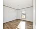 A bedroom with neutral walls, modern flooring, and natural light from a window at 525 Mt. Wesley Church Rd, Hiddenite, NC 28636