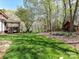 Expansive back yard featuring lush lawn, mature trees, covered patio, and charming playhouse at 5301 Greyfriar Ct, Waxhaw, NC 28173