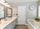 Bright bathroom features dual sinks, a bathtub, modern lighting and wood look flooring at 5301 Greyfriar Ct, Waxhaw, NC 28173