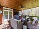 Comfortable outdoor covered patio with ceiling fan, stylish furniture, grill, and wooded views at 5301 Greyfriar Ct, Waxhaw, NC 28173