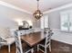 Elegant dining room with a modern light fixture, hardwood floors, and wainscoting at 5301 Greyfriar Ct, Waxhaw, NC 28173