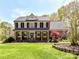 Charming two-story brick home with a well-manicured front lawn, American flag, and mature trees at 5301 Greyfriar Ct, Waxhaw, NC 28173