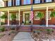Inviting front porch with rocking chairs, hanging ferns, and an American flag at 5301 Greyfriar Ct, Waxhaw, NC 28173