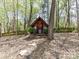 Charming playhouse nestled among the trees with a decorative wreath and small porch at 5301 Greyfriar Ct, Waxhaw, NC 28173