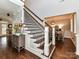 Grand staircase showcasing dark wood treads and white risers with dining room in the background at 5301 Greyfriar Ct, Waxhaw, NC 28173
