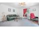 Comfortable living room featuring a green sofa, desk space, and ample natural light, creating a warm and inviting space at 6575 Charlotte Hwy, York, SC 29745