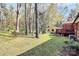 View of spacious backyard with shade trees and deck at 7034 Leaves Ln, Charlotte, NC 28213