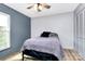 Cozy bedroom features two-tone walls, a wood-look floor, and natural light from the window at 7034 Leaves Ln, Charlotte, NC 28213