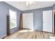 Bedroom with light blue walls, wood-look floors, a window, and a closet with folding doors at 7034 Leaves Ln, Charlotte, NC 28213