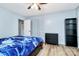 Bedroom featuring light blue walls, wood-look floors, bed with blue comforter, and closet with folding doors at 7034 Leaves Ln, Charlotte, NC 28213