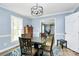 Cozy dining room with stylish light fixture, blue walls, and wood flooring at 7034 Leaves Ln, Charlotte, NC 28213