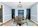 Dining room featuring modern light fixture, blue walls, wood flooring, and storage shelves at 7034 Leaves Ln, Charlotte, NC 28213