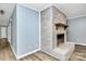 Painted brick fireplace featuring a wooden mantle and hardwood floors at 7034 Leaves Ln, Charlotte, NC 28213