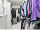 Bright walk-in closet with hanging clothes racks, shelves, and white marble patterned floors at 7034 Leaves Ln, Charlotte, NC 28213