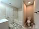 Clean bathroom with a soaking tub and sleek marble-look tile floor at 7147 Henderson Valley Ln, Charlotte, NC 28269