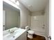 Bathroom with light walls, a white sink, bathtub, and modern toilet at 7147 Henderson Valley Ln, Charlotte, NC 28269