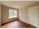Bedroom featuring hardwood flooring, neutral paint, natural light, and a door at 7147 Henderson Valley Ln, Charlotte, NC 28269