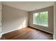 Bedroom with hardwood floors, neutral paint, natural light, and a door at 7147 Henderson Valley Ln, Charlotte, NC 28269