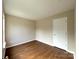 A cozy bedroom offers wood-look floors, neutral paint, and closet storage at 7147 Henderson Valley Ln, Charlotte, NC 28269
