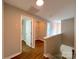 Hallway showcasing hardwood floors, neutral paint, bathroom, and utility closet at 7147 Henderson Valley Ln, Charlotte, NC 28269